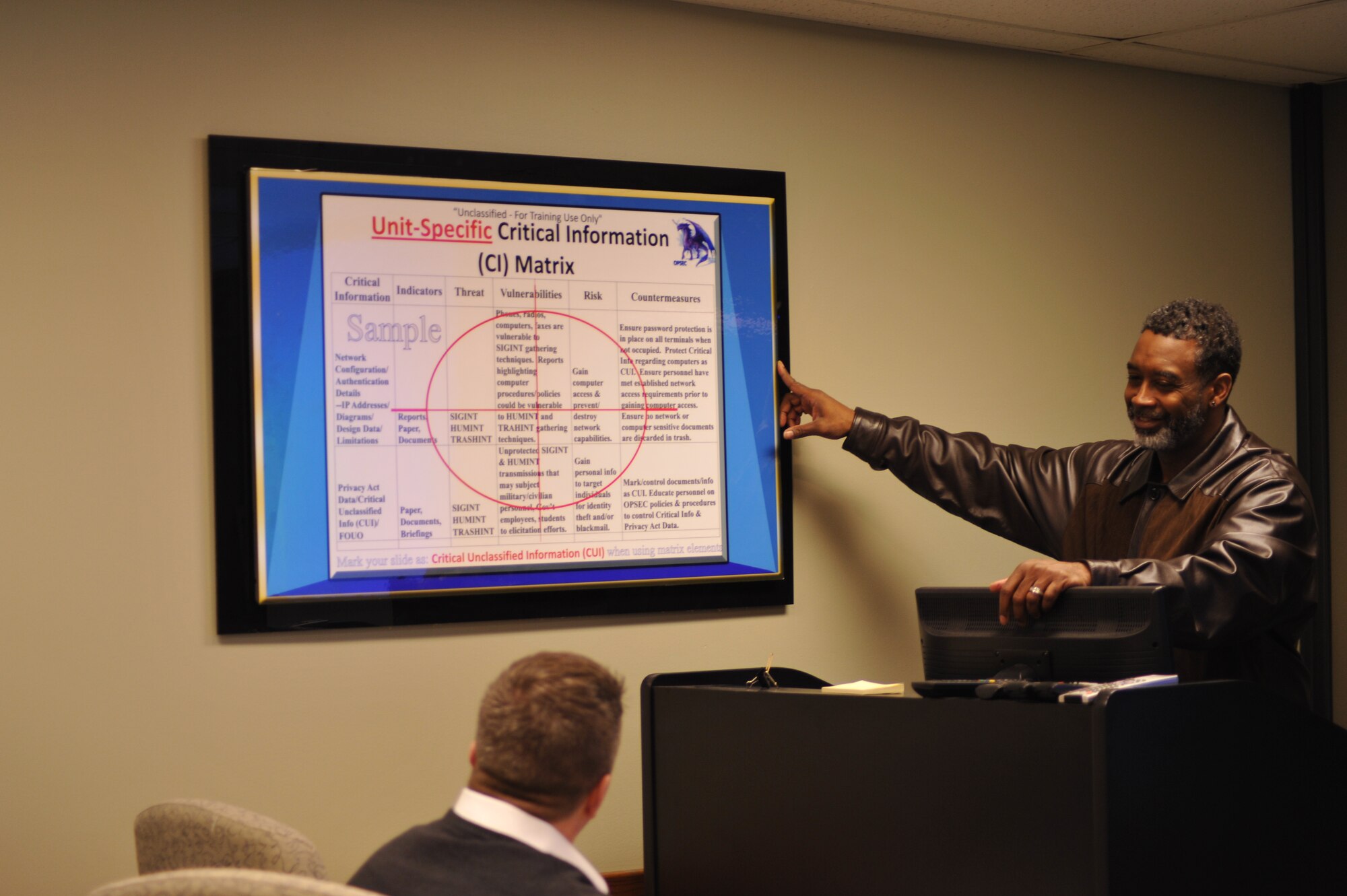 Ed Benton (standing) teaches Operations Security courses as James Johnson observes.  (U.S. Air Force photo/Sandy Simison)  