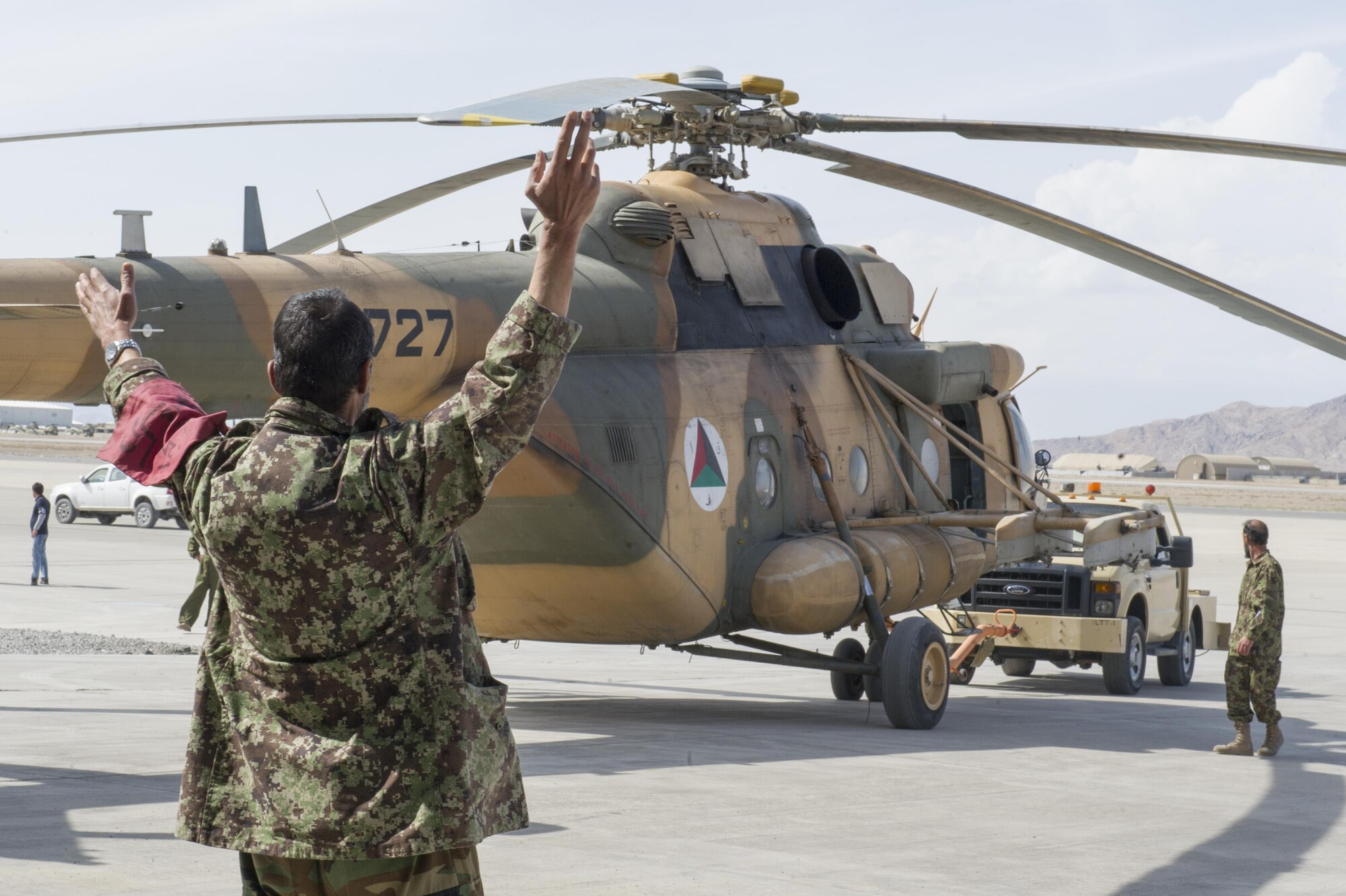 An Afghan Air Force member guides an Mi-17 helicopter, owned and operated by the Kandahar Air Wing, to a hangar to receive maintenance at Kandahar Airfield, March 2, 2016. Members of the AAF work closely with Train Advise Assist Command - Air, a U.S. run functional command, that supports NATO's Resolute Support mission assists our Afghan partners to develop a professional, capable and sustainable force. (U.S. Air Force photo/Tech. Sgt. Robert Cloys)