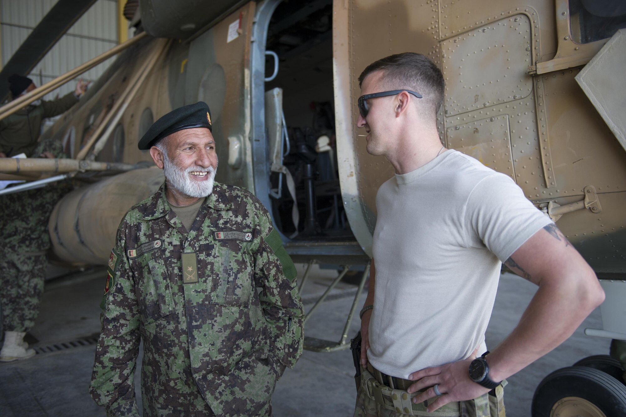 Tech. Sgt. Richard Embrey, Train Advise Assist Command - Air Mi-17 Intermediate Maintenance Squadron advisor, talks with Afghan Air Force Maj. Gulwali, support equipment officer in charge, during a 100-hour inspection on an Mi-17 helicopter at Kandahar Airfield, Afghanistan, March 2, 2016. As a functional command, TAAC-Air assists our Afghan partners to develop a professional, capable and sustainable force. (U.S. Air Force photo/Tech. Sgt. Robert Cloys)