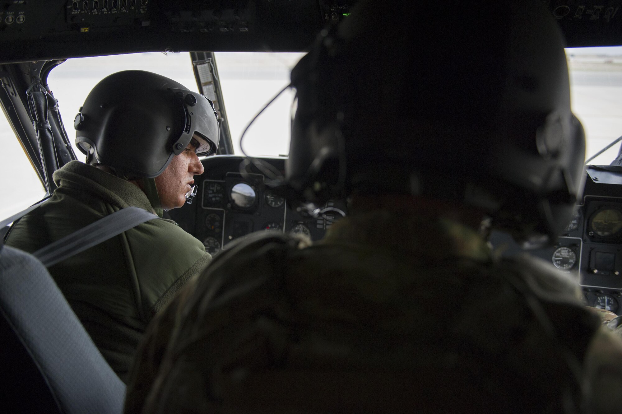 An Afghan Air Force pilot powers down an Mi-17 helicopter as Master Sgt Justin Kay, Train Advise Assist Command-Air Mi-17 flight engineer, observes after a training mission at Kandahar Airfield, Afghanistan, March 3, 2016. TAAC-Air works closely with AAF partners to develop a professional, capable, and sustainable Air Force. (U.S. Air Force Photo/Tech. Sgt. Robert Cloys)