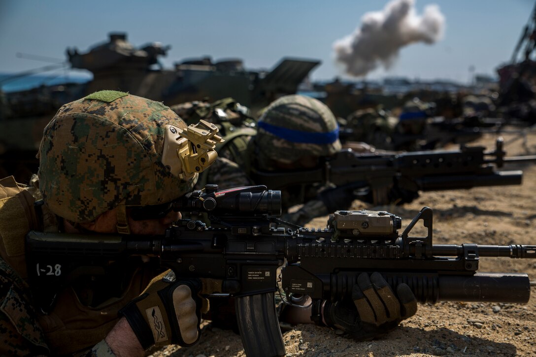 Marines provide security as an amphibious assault vehicles come ashore during Exercise Ssang Yong 16, March 12, 2016. Ssang Yong 16 is a biennial combined amphibious exercise conducted by forward-deployed U.S. forces with the Republic of Korea Navy and Marine Corps, Australian Army and Royal New Zealand Army Forces in order to strengthen our interoperability and working relationships across a wide range of military operations - from disaster relief to complex expeditionary operations.  Hill is part of 5th Naval Air Liaison Company.