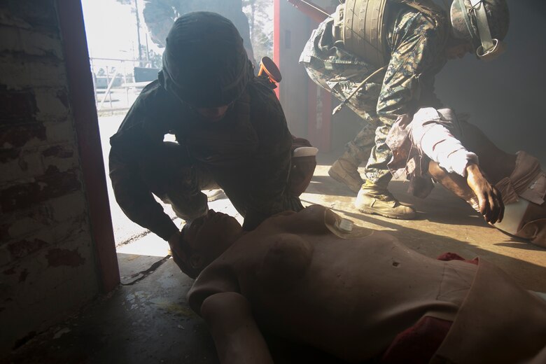 Marines and sailors drag their mannequins to the evacuation point during the combat life-savers course at Camp Lejeune N.C., March 10, 2016. This kind of realistic training allows Marines and sailors to work together and allows them to experience caring for a large amount of casualties. (U.S. Marine Corps photo by Lance Cpl. Luke Hoogendam/Released.)
