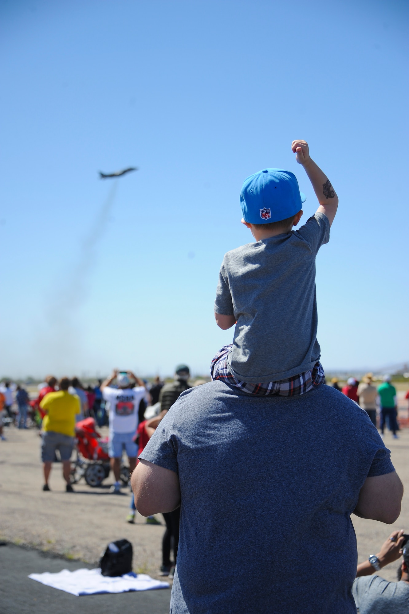 Spectators cheered during the U.S. Marine Corps AV-8 Harrier demonstration during Thunder and Lightning over Arizona Open House at Davis-Monthan Air Force Base, Ariz., March 12, 2016. The Open House was an opportunity for D-M Airmen to show their appreciation to the local community for their support to the base. (U.S. Air Force photo by Airmen 1st Class Ashley N. Steffen/Released)