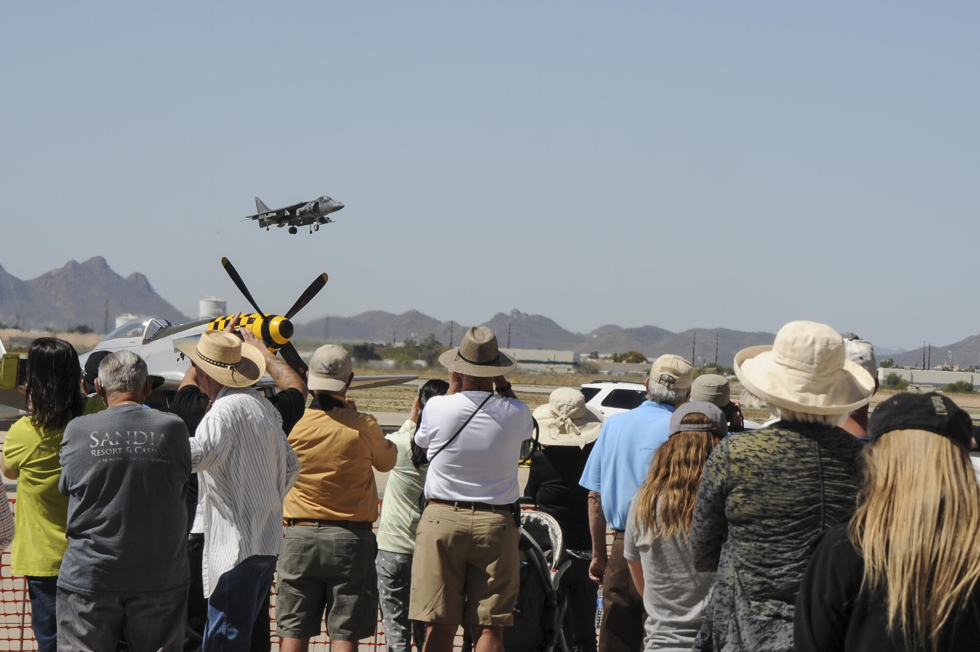 Spectators watch the U.S. Marine Corps AV-8 Harrier demonstration during Thunder and Lightning over Arizona Open House at Davis-Monthan Air Force Base, Ariz., March 12, 2016. The Open House was an opportunity for D-M Airmen to show their appreciation to the local community for their support to the base. (U.S. Air Force photo by Airman 1st Class Mya M. Crosby/Released)
