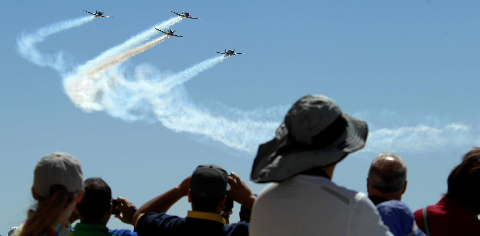The Desert Rats Warbirds fly in a formation over spectators during the Thunder and Lightning over Arizona Open House at Davis-Monthan Air Force Base, Ariz., March 12, 2016. The Open House featured 12 aerial demonstrations and 51 aircraft static displays for patrons’ entertainment.  (U.S. Air Force photo by Senior Airman Camilla Elizeu/Released)