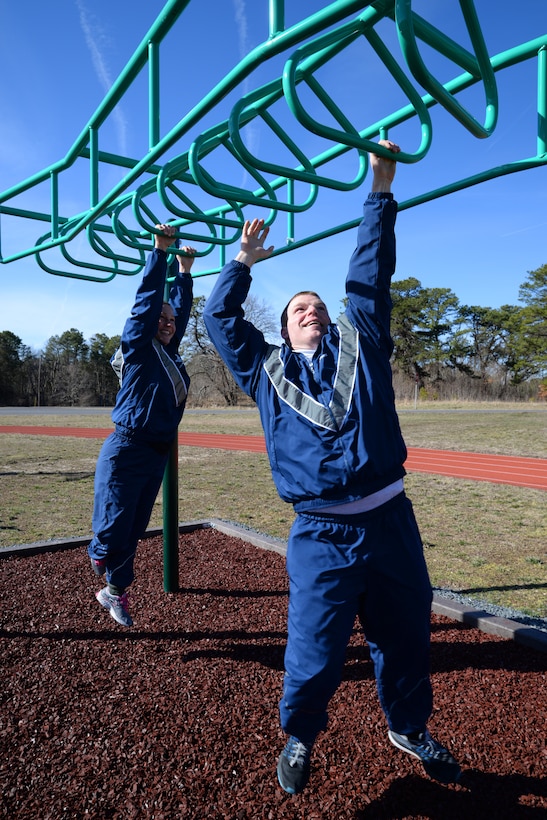 U.S. Air Force Tech. Sgts. Rosemarie Perry, left, and Bob Johnson, with the 177th Fighter Wing Logistics Readiness Squadron, New Jersey Air National Guard, try out new workout stations located alongside the on-base running track at the Atlantic City Air National Guard Base, N.J. on Mar. 3, 2016. New workout stations include: the back extension, horizontal bars, push up bars, a sit up bench, the sky climber (a variation of a horizontal ladder), and uneven bars, and can be used for high-intensity workouts including cardio and strength intervals. (U.S. Air National Guard photo by Master Sgt. Andrew J. Moseley/Released)