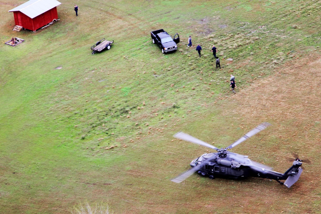 A UH-60 Black Hawk helicopter delivers people stranded by floodwaters to emergency crews during flood response operations in Winnfield, La., March 10, 2016. Louisiana Army National Guard photo by Spc. Megan Zander