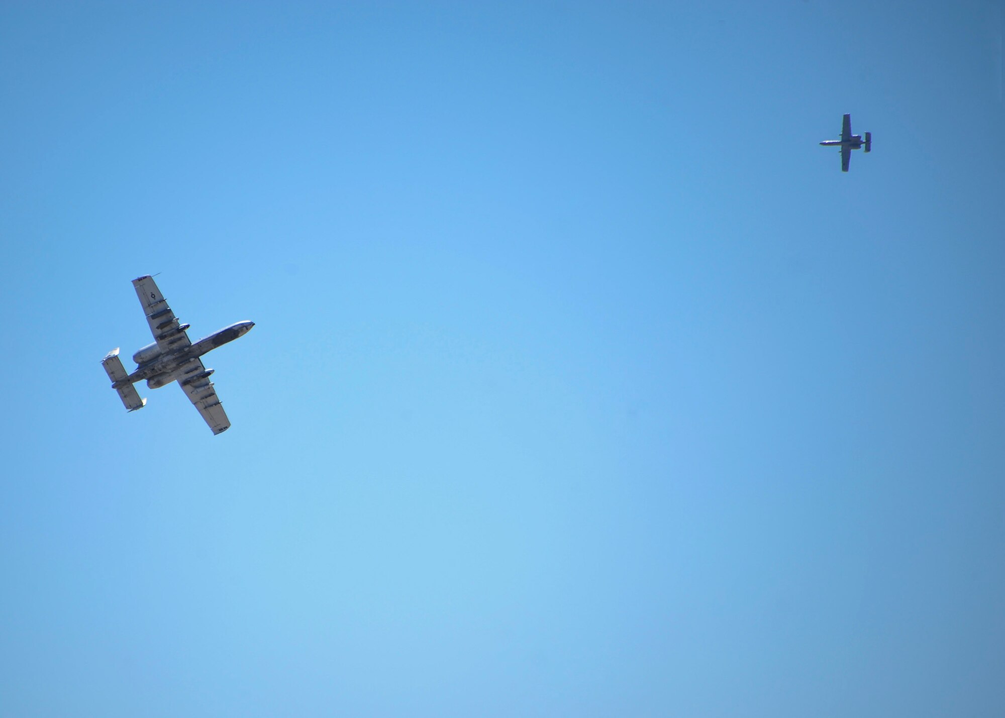 Two A-10 Thunderbolt IIs preform an aerial maneuver for a rescue demonstration during the Thunder and Lightning over Arizona Open House at Davis-Monthan Air Force Base, Ariz., March 13, 2016. The wide combat radius and short take off and landing capability allow A-10’s to operate in and out of locations near front lines. (U.S. Air Force photo by Airmen 1st Class Ashley N. Steffen/Released)