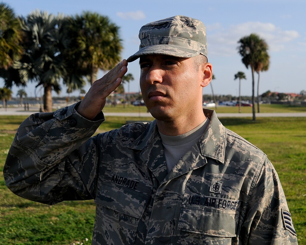 Staff Sgt. Adilson Andrade, a flag detail member, salutes as the American flag is lowered during a retreat ceremony at MacDill Air Force Base, Fla., March 9, 2016. Retreat not only signals the end of the duty day, but also pays respect to the flag. (U.S. Air Force photo by Airman 1st Class Mariette Adams)