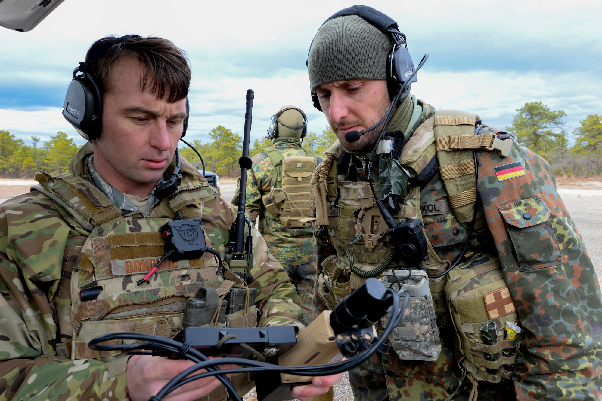 A picture of U.S. Air Force Tech. Sgt. Chris Donohue, Joint Terminal Attack Controller (JTAC) with the 227th Air Support Operations Squadron (ASOS), and German armed forces JTAC 1st Lt. Marius Sokol preparing equipment for close air support training.