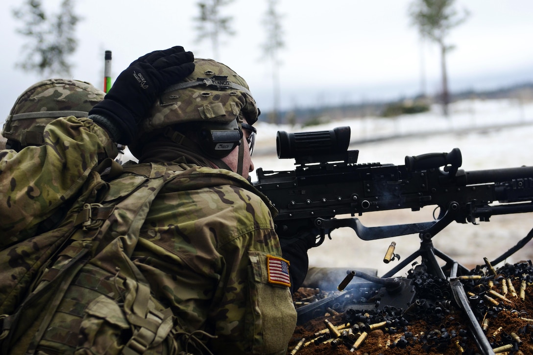 A soldier taps a machine-gunner on the helmet to signify when to shoot at enemy targets during a live-fire exercise at Tapa Training Area in Estonia, March 12, 2016. Army photo by Staff Sgt. Steven M. Colvin