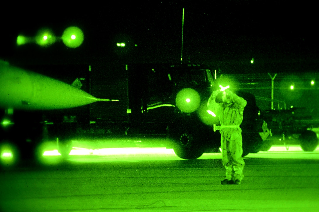As seen through a night-vision device, an airman marshals an F-16 Fighting Falcon aircraft onto the flight line during Exercise Dastardly Devil 16-1 at the Atlantic City Air National Guard Base, N.J., March 12, 2016. New Jersey Air National Guard photo by Tech. Sgt. Andrew Merlock