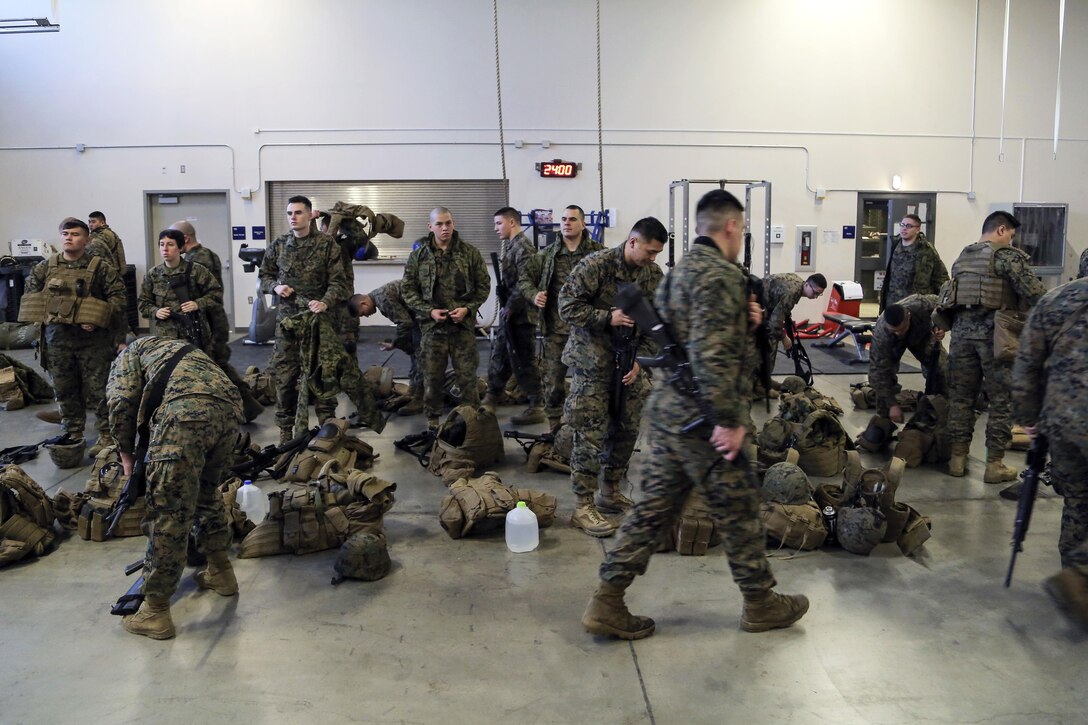 Marines put on their gear and prepare to conduct urban operations training on Joint Base Elmendorf-Richardson, Alaska, March 6, 2016. The Marines are assigned to Detachment Military Police Delta Company, 4th Law Enforcement Battalion. The training prepared the Marines for their upcoming deployment to Serbia where they will serve as military police advisors. Air Force photo by Alejandro Pena