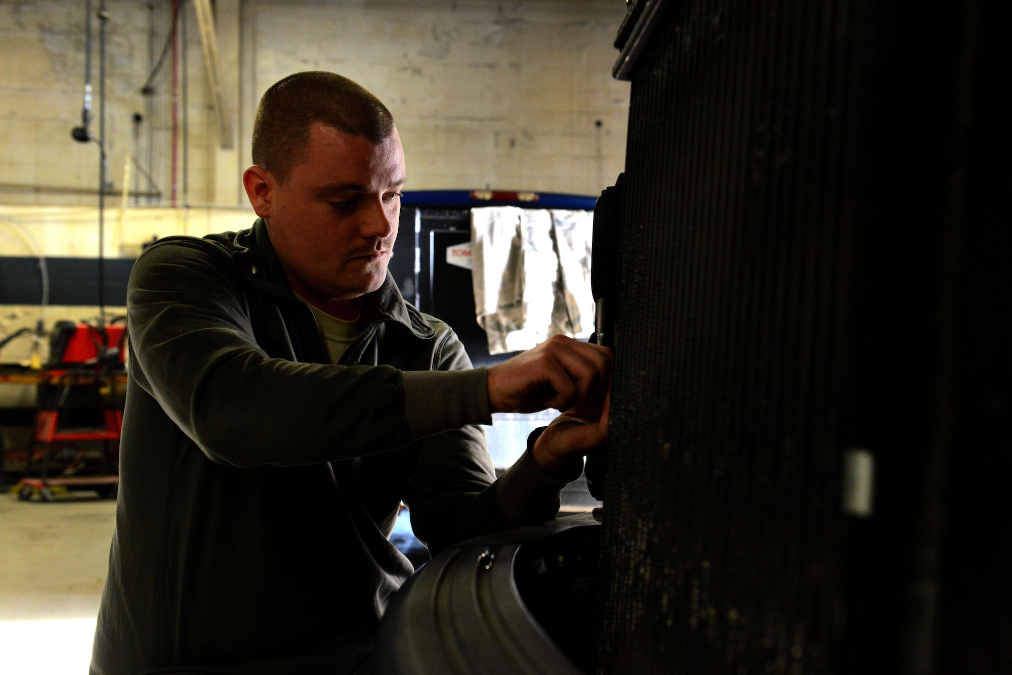 U.S. Air Force Staff Sgt. Trent Tillman, 20th Logistics Readiness Squadron vehicle maintenance flight material handling equipment maintainer, attaches a headlight to a vehicle at Shaw Air Force Base, S.C., March 8, 2016. The 20th LRS VMF is responsible for a variety of vehicles including emergency vehicles, refueling trucks, and cargo loaders. (U.S. Air Force photo by Airman 1st Class Destinee Dougherty)