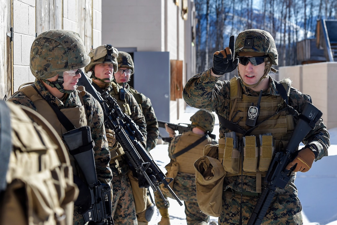 Marine Corps Cpl. William Worthy, right, directs his squad while clearing a complex during urban terrain training on Joint Base Elmendorf-Richardson, Alaska, March 6, 2016. Worthy is assigned to Detachment Military Police Delta Company, 4th Law Enforcement Battalion. Air Force photo by Alejandro Pena