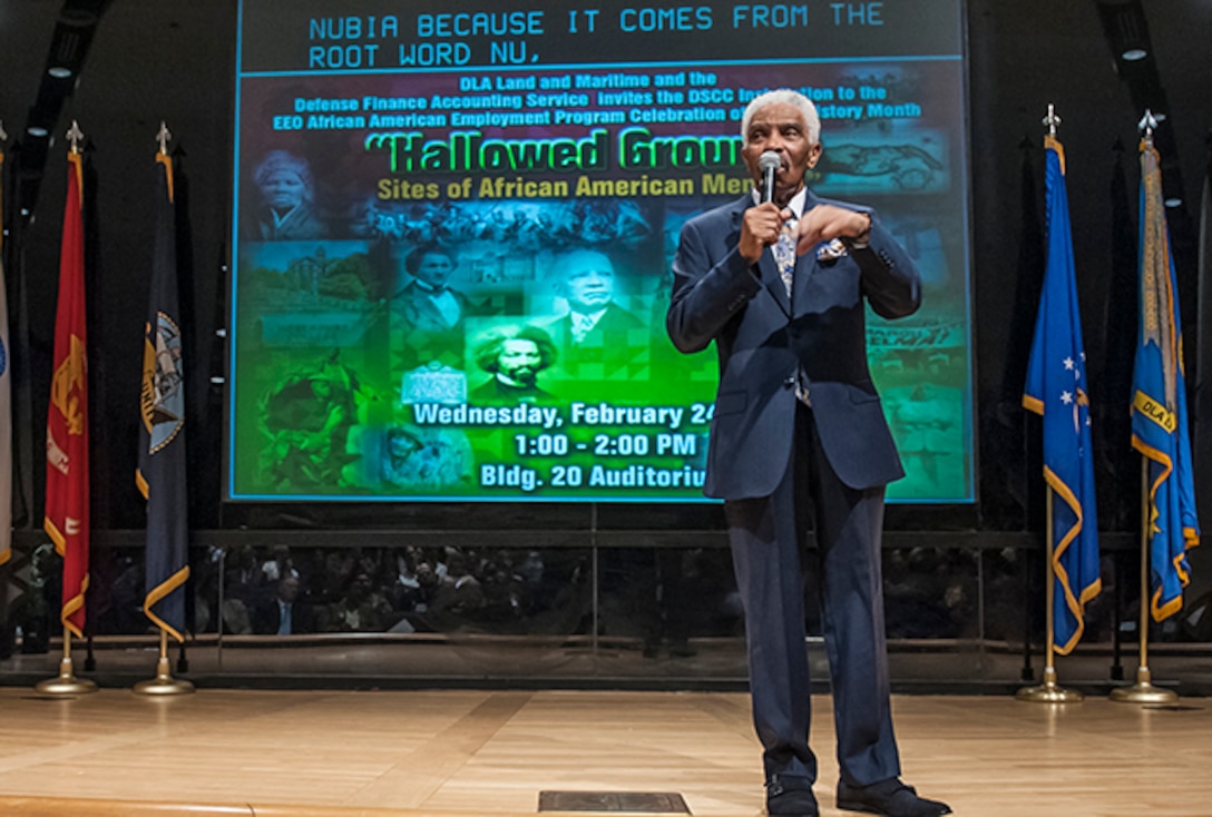 Charles Tennant, Sr. addresses the audience gathered in the Building 20 auditorium during the installation’s Black History Month observance. Tennant kept the audience riveted will delivering a factual and entertaining history lesson highlighting African American contributions 
