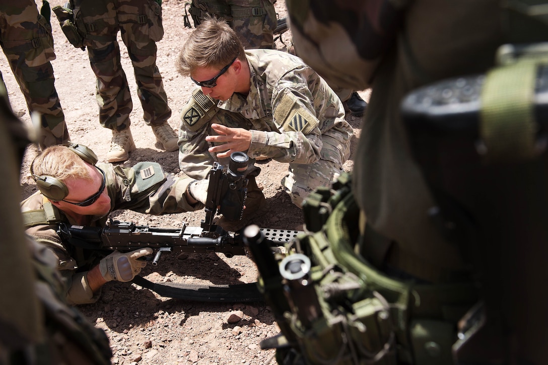 A U.S. soldier, center right, teaches French Foreign Legion soldiers how to properly operate an M240L machine gun at a firing range in Djibouti, March 5, 2016. Air Force photo by Tech. Sgt. Barry Loo