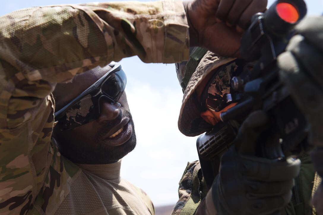 A U.S. soldier, left, teaches a French Foreign Legion soldier how to properly operate an M4 carbine rifle at a firing range in Djibouti, March 5, 2016. Air Force photo by Tech. Sgt. Barry Loo