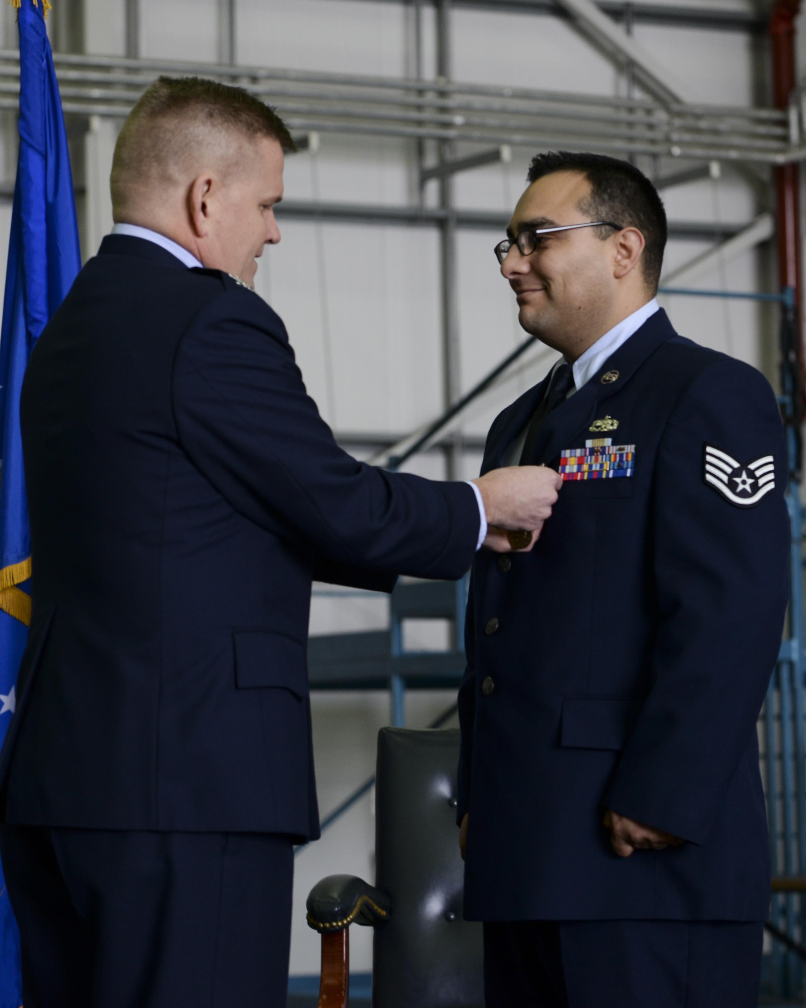 Col. Thomas D. Torkelson, the 100th Air Refueling Wing commander, presents Staff Sgt. Vicente Gomez, a 100th Aircraft Maintenance Squadron crew chief, with the Airman’s Medal during a ceremony March 11, 2016, on Royal Air Force Mildenhall, England. Gomez received the honor for his courageous acts performed on May 12, 2014 by saving the lives of two victims from a potentially fatal car accident. (U.S. Air Force photo/Senior Airman Victoria H. Taylor)