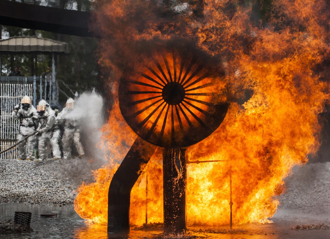 A team of 919th Special Operations Civil Engineer Squadron firefighters move in to battle an engine fire during a live-fire training exercise March 4 at Hurlburt Field, Fla.  The Reserve Airmen teamed with their active-duty special operations firefighters to complete their annual live-fire training during the March unit training assembly.  (U.S. Air Force photo/Tech. Sgt. Sam King)