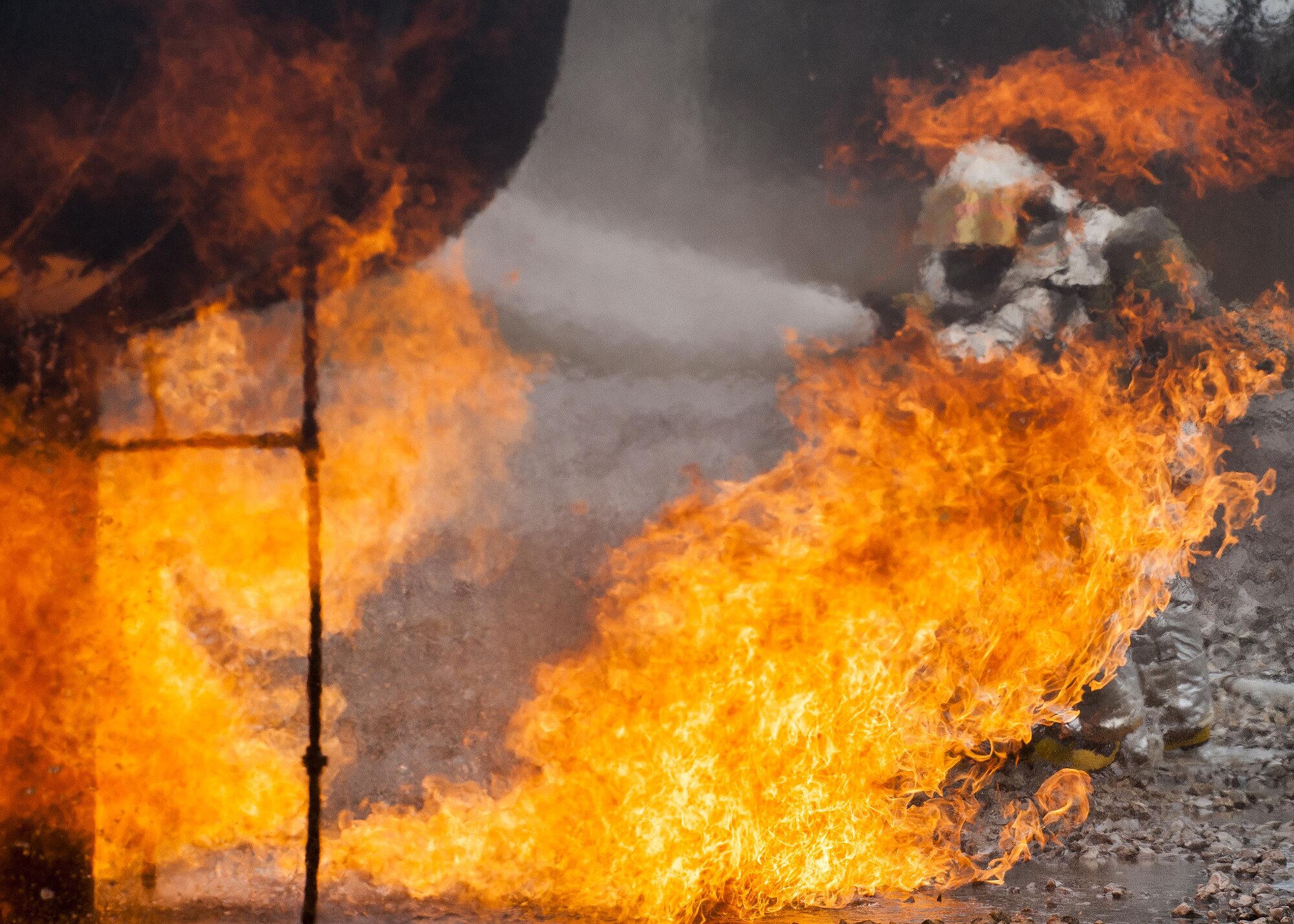 A team of 919th Special Operations Civil Engineer Squadron firefighters move in to battle an engine fire during a live-fire training exercise March 4 at Hurlburt Field, Fla.  The Reserve Airmen teamed with their active-duty special operations firefighters to complete their annual live-fire training during the March unit training assembly.  (U.S. Air Force photo/Tech. Sgt. Sam King)