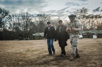 1st Lt. Charles W. Breeden, commander of the 309th Transportation Detachment, walks with civilian roleplayers acting as tribal representatives during Combat Support Training Exercise 2016 at Joint Base McGuire-Dix-Lakehurst, N.J. March 8, 2016. CSTX is a U.S. Army Reserve exercise conducted at multiple locations across the country designed to challenge combat support units and Soldiers to improve and sustain skills necessary during a deployment. (U.S. Army photo by Sgt. Michael T. Crawford/RELEASED)