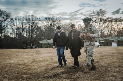 1st Lt. Charles W. Breeden, commander of the 309th Transportation Detachment, walks with civilian roleplayers acting as tribal representatives during Combat Support Training Exercise 2016 at Joint Base McGuire-Dix-Lakehurst, N.J. March 8, 2016. CSTX is a U.S. Army Reserve exercise conducted at multiple locations across the country designed to challenge combat support units and Soldiers to improve and sustain skills necessary during a deployment. (U.S. Army photo by Sgt. Michael T. Crawford/RELEASED)