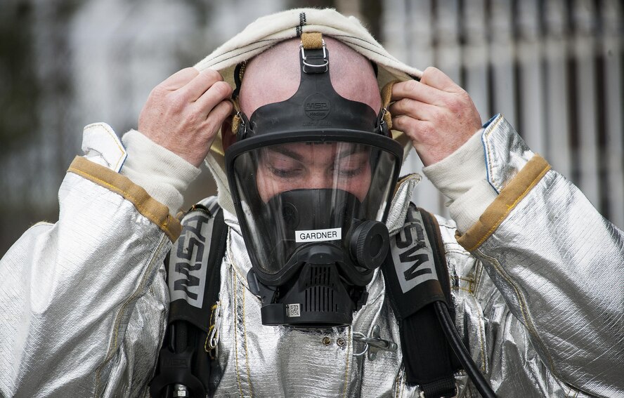 Senior Airman Josh Brown, 919th Special Operations Civil Engineer Squadron, pulls on a protective hood prior to a live-fire training exercise March 4 at Hurlburt Field, Fla.  The Reserve Airmen teamed with their active-duty special operations firefighters to complete their annual live-fire training during the March unit training assembly.  (U.S. Air Force photo/Tech. Sgt. Sam King)