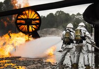 A team of 919th Special Operations Civil Engineer Squadron firefighters move in to battle an engine fire during a live-fire training exercise March 4 at Hurlburt Field, Fla.  The Reserve Airmen teamed with their active-duty special operations firefighters to complete their annual live-fire training during the March unit training assembly.  (U.S. Air Force photo/Tech. Sgt. Sam King)