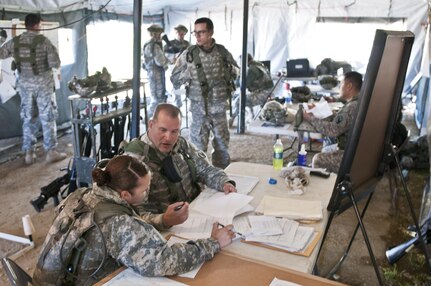 Staff Sgt. Carlos Diaz and Spc. Charlene Suliz, construction engineers with the 475th Engineer Company (Horizontal), an Army Reserve unit from Puerto Rico, review the day's plans during Combat Support Training Exercise 78-16-01 at Fort Hunter Liggett, Calif., March 8, 2016. CSTX 78-16-01 is a U.S. Army Reserve exercise conducted at multiple locations across the country designed to challenge combat support units and Soldiers to improve and sustain skills necessary during a deployment. (U.S. Army photo by Staff Sgt. Dalton Smith/Released)