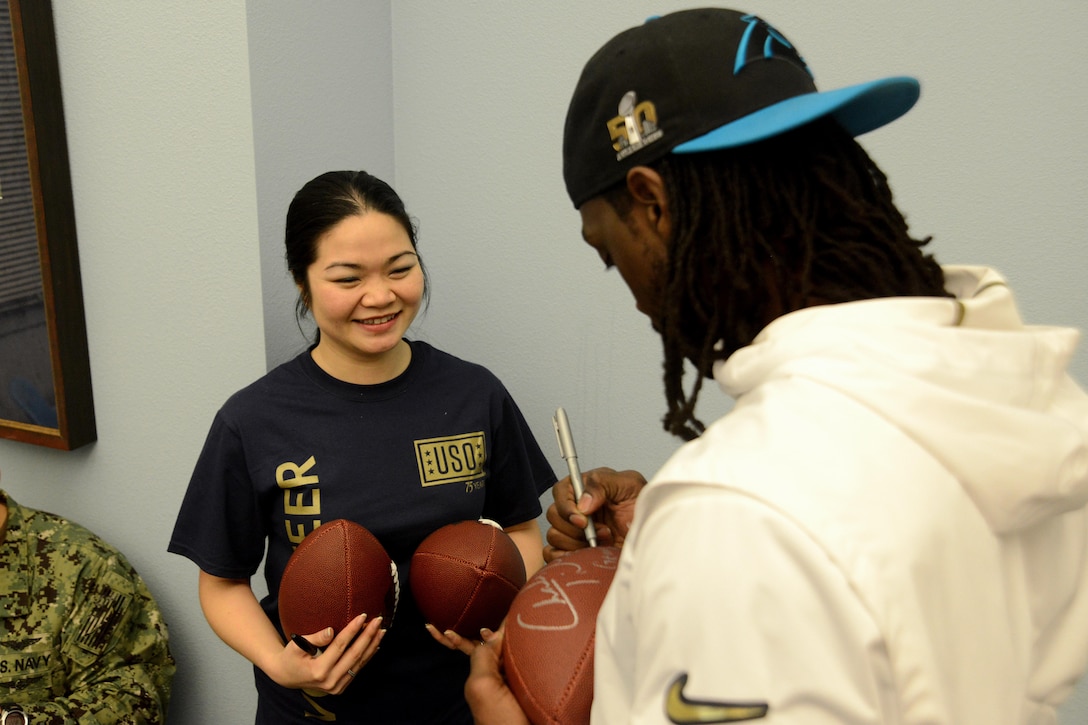 Carolina Panthers football player Charles Tillman, right, autographs footballs for a USO volunteer member during the USO spring tour on Joint Base Elmendorf-Richardson, Alaska, March 12, 2016. Air Force photo by Airman 1st Class Christopher R. Morales