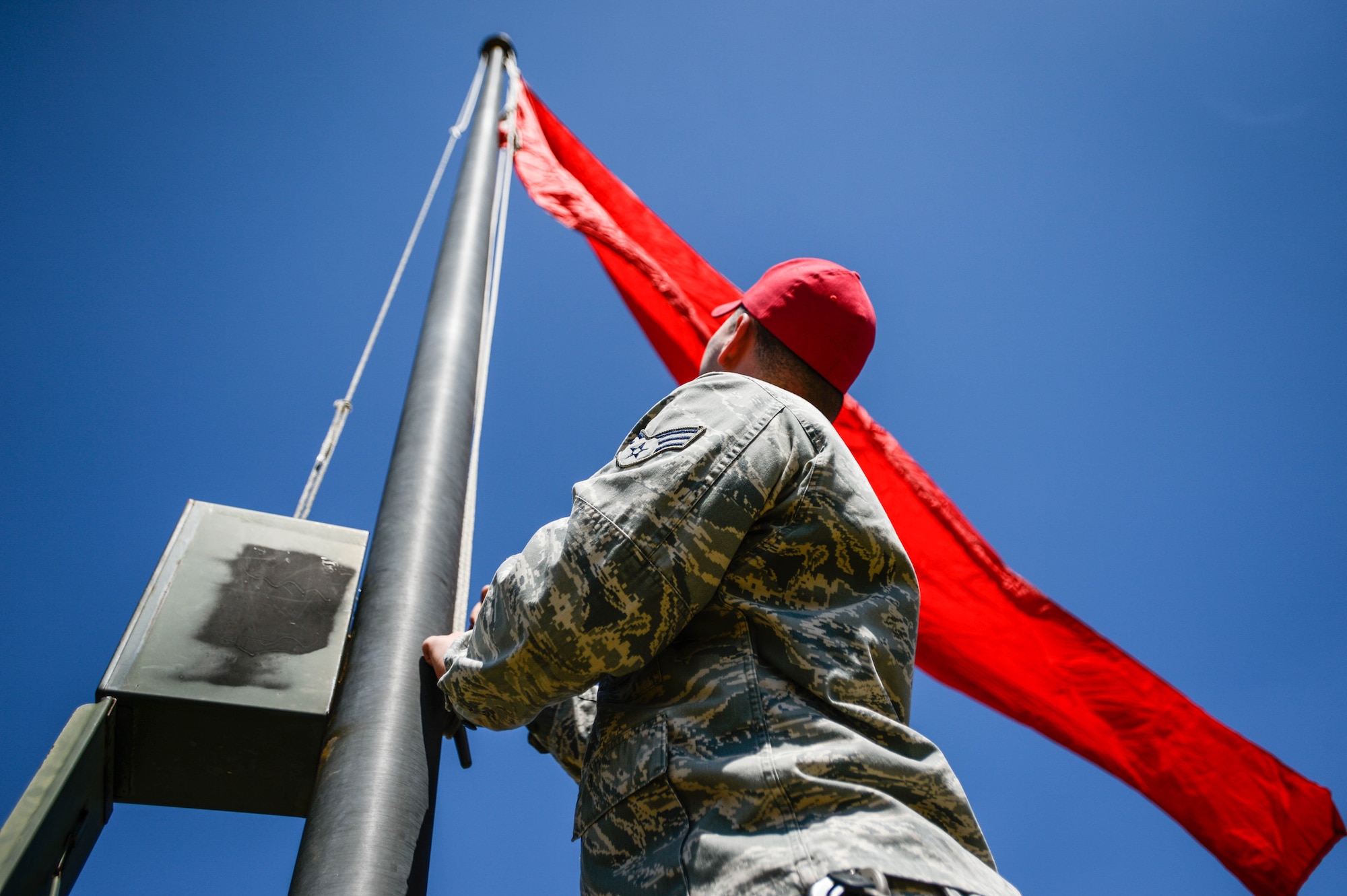 U.S. Air Force Staff Sgt. Jason Mufford, 20th Security Forces Squadron combat arms instructor, raises a flag signaling “live fire” at Shaw Air Force Base, S.C., March 08, 2016. The red flag lets the base populace know when Team Shaw members are firing weapons at the combat arms range. (U.S. Air Force photo by Senior Airman Jensen Stidham)
