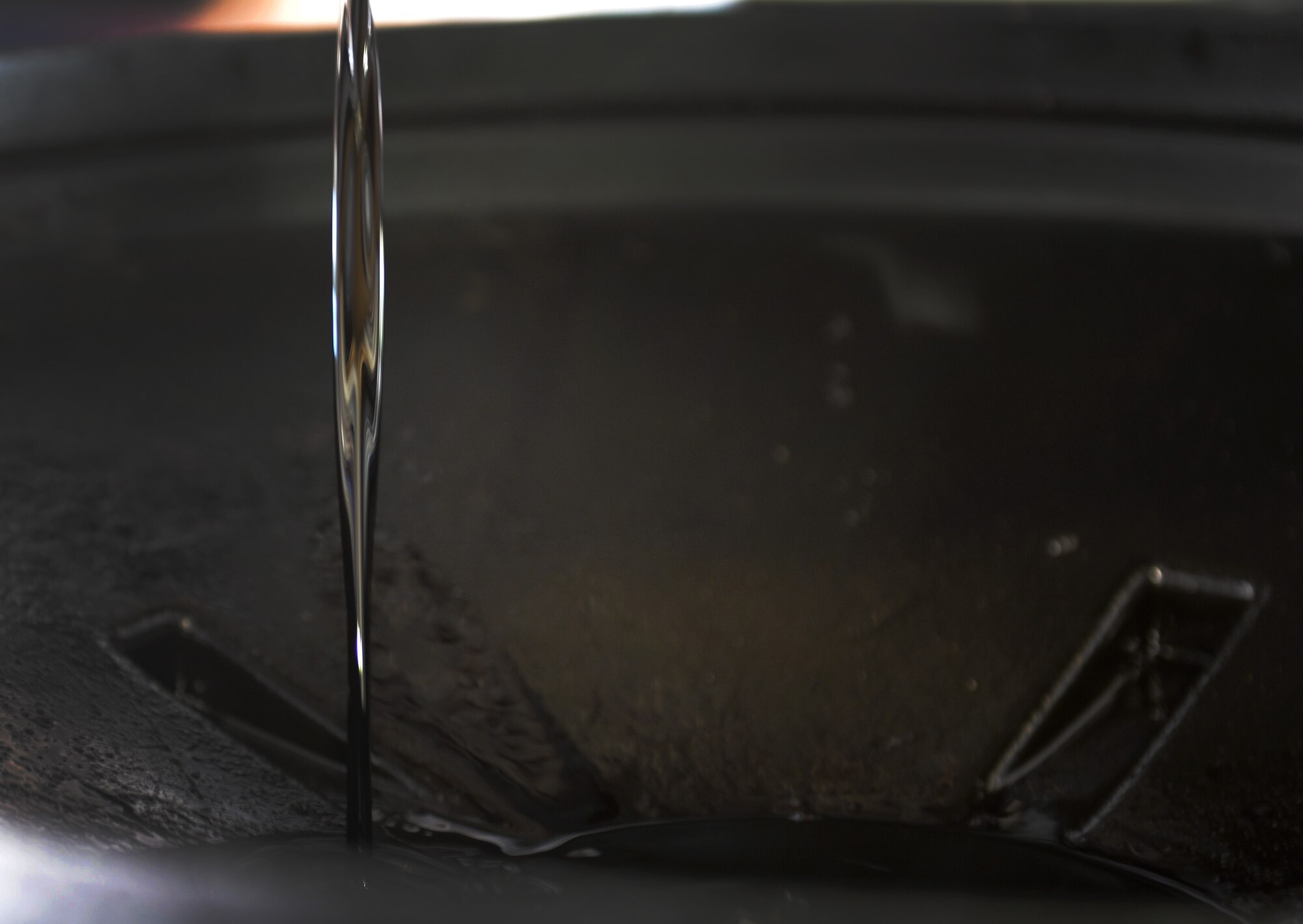 Oil drains into an oil pan at the Auto Hobby Shop Feb. 28, 2016, Keesler Air Force Base, Miss. It offers A/C checks, vehicle fluid collection, outdoor and indoor stalls with lifts, dozens of available tools and other services. The Auto Hobby Shop is open to anyone with base access Fridays 12 p.m. – 7 p.m., Saturdays and Sundays 9 a.m. – 4 p.m. (U.S. Air Force photo by Airman 1st Class Travis Beihl)
