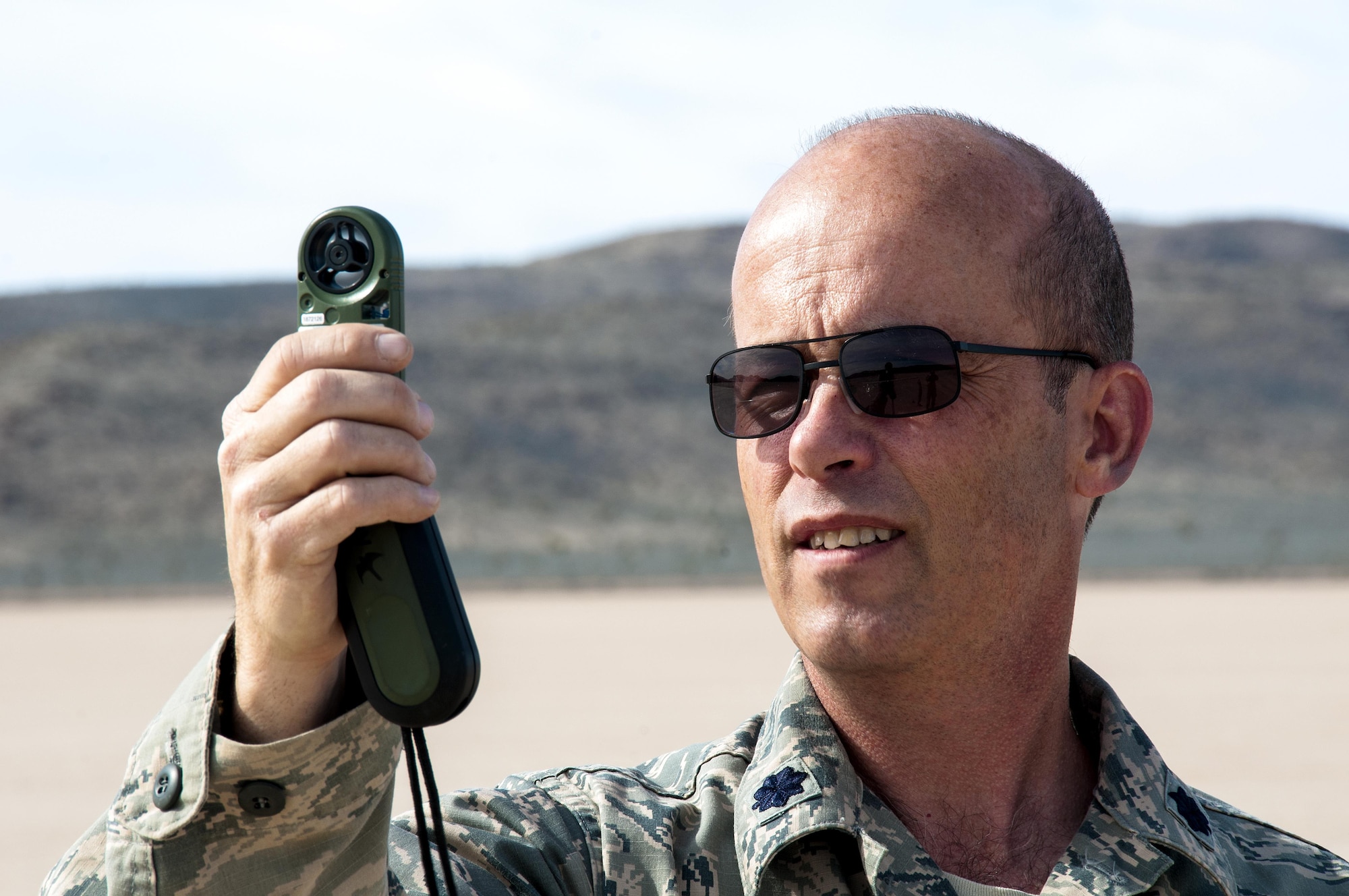 Lt. Col. Greg Pelech, 94th Airlift Wing chief of safety, tests the wind speed for an air drop in the desert near Nellis Air Force Base, Nev. during Red Flag 16-2 March 5, 2016. Red Flag is an exercise hosted by Nellis Air Force Base, Nev. that provides aircrews an opportunity to experience realistic, stressful combat situations in a controlled environment to increase mission capability. (U.S. Air Force photo/Staff Sgt. Daniel Phelps)

