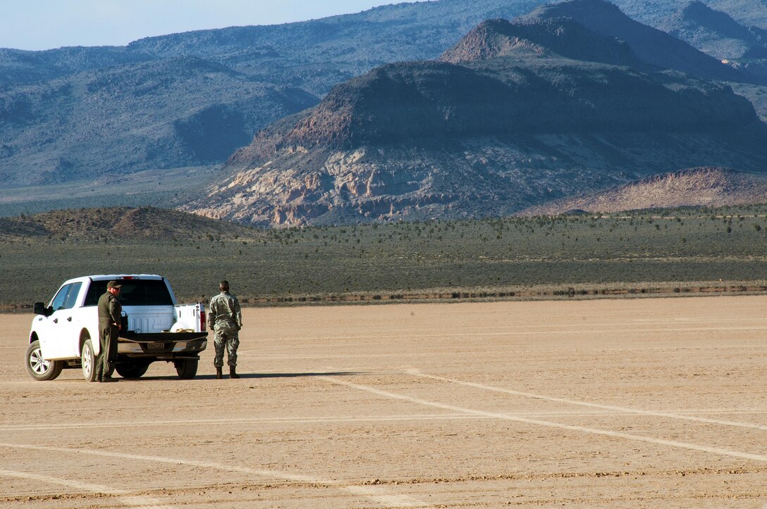 Members from the 94th Airlift Wing await for supplies dropped from C-130 Hercules in the drop zone during Red Flag 16-2 in the desert near Nellis Air Force Base, Nev., March 5, 2016. Red Flag is an exercise hosted by Nellis Air Force Base, Nev. that provides aircrews an opportunity to experience realistic, stressful combat situations in a controlled environment to increase mission capability. (U.S. Air Force photo/Staff Sgt. Daniel Phelps)
