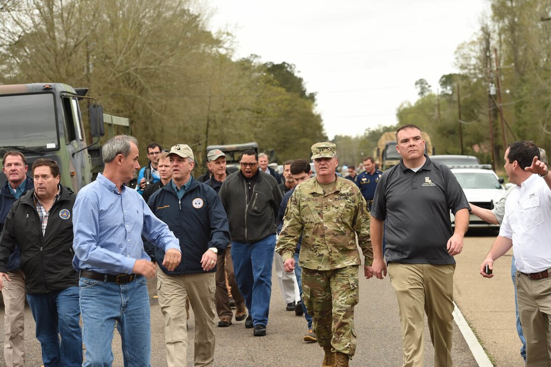 Louisiana Gov. John Bel Edwards, center left, in dark blue jacket, surveys flooded areas in Ponchatoula, La., March 12, 2016. Edwards thanked Louisiana National Guardsmen for their efforts to support response operations following widespread flooding in the state. Louisiana National Guard photo by Air Force Master Sgt. Toby M. Valadie