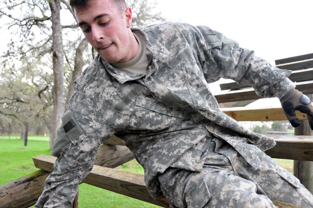 Spc. Connor Walraven, assigned to the U.S. Army Reserve's 319th Army Band at Fort Totten, N.Y., works his way through the "weaver" during the obstacle course portion of the 99th Regional Support Command three-day Best Warrior Competition March 10-12 at Camp Bullis, Texas.