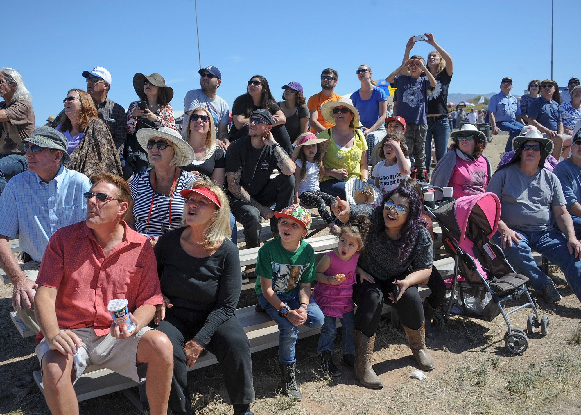 Spectators observe Kent Pietsch operate the Jelly Belly airplane as he performs aerial demonstrations during the Thunder and Lightning over Arizona Open House event at Davis-Monthan Air Force Base, Ariz., March 13, 2016. Pietsch flies the 800-pound Interstate Cadet with a 37-foot wingspan. (U.S. Air Force photo by Airmen 1st Class Ashley N. Steffen/Released)