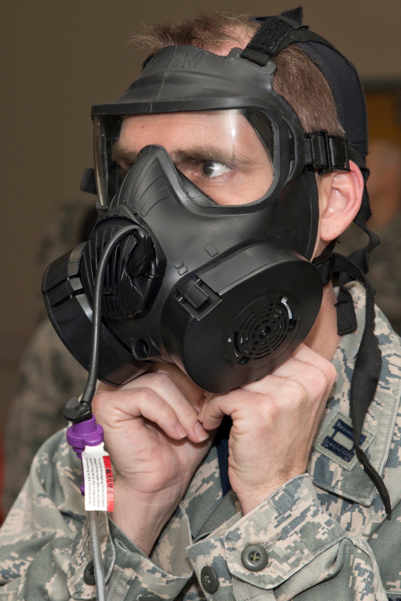 U.S. Air Force Reserve Capt. Benjamin Hulsey, the officer in charge, command post, for the 913th Airlift Group, makes adjustments during a gas mask fit test at Little Rock Air Force Base, Ark., Mar. 13, 2016. The test covers five areas: deep and normal breathing, turning of the head from left to right, nodding up and down and chewing. (U.S. Air Force photo by Master Sgt. Jeff Walston/Released)