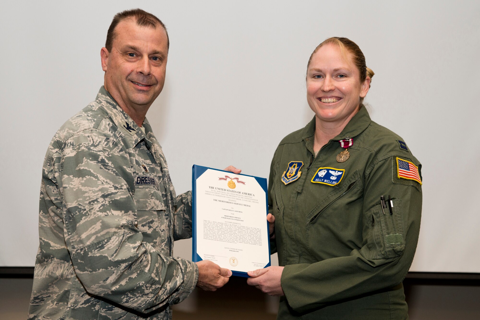 U.S. Air Force Reserve Col. Craig Drescher, commander, 913th Airlift Group, and Capt. Kelly Welling, instructor pilot, 327th Airlift Squadron, pose for a photo during a commander’s call at Little Rock Air Force Base, Ark., Mar. 13, 2016. Welling was awarded the Meritorious Service Medal for outstanding achievement as the C-130H Instructor Pilot and Aircrew Flight Equipment Officer from 6 March 2012 to 31 March 2015. Drescher also recognized 11 additional individuals for personal achievements. (U.S. Air Force photo by Master Sgt. Jeff Walston/Released) 
