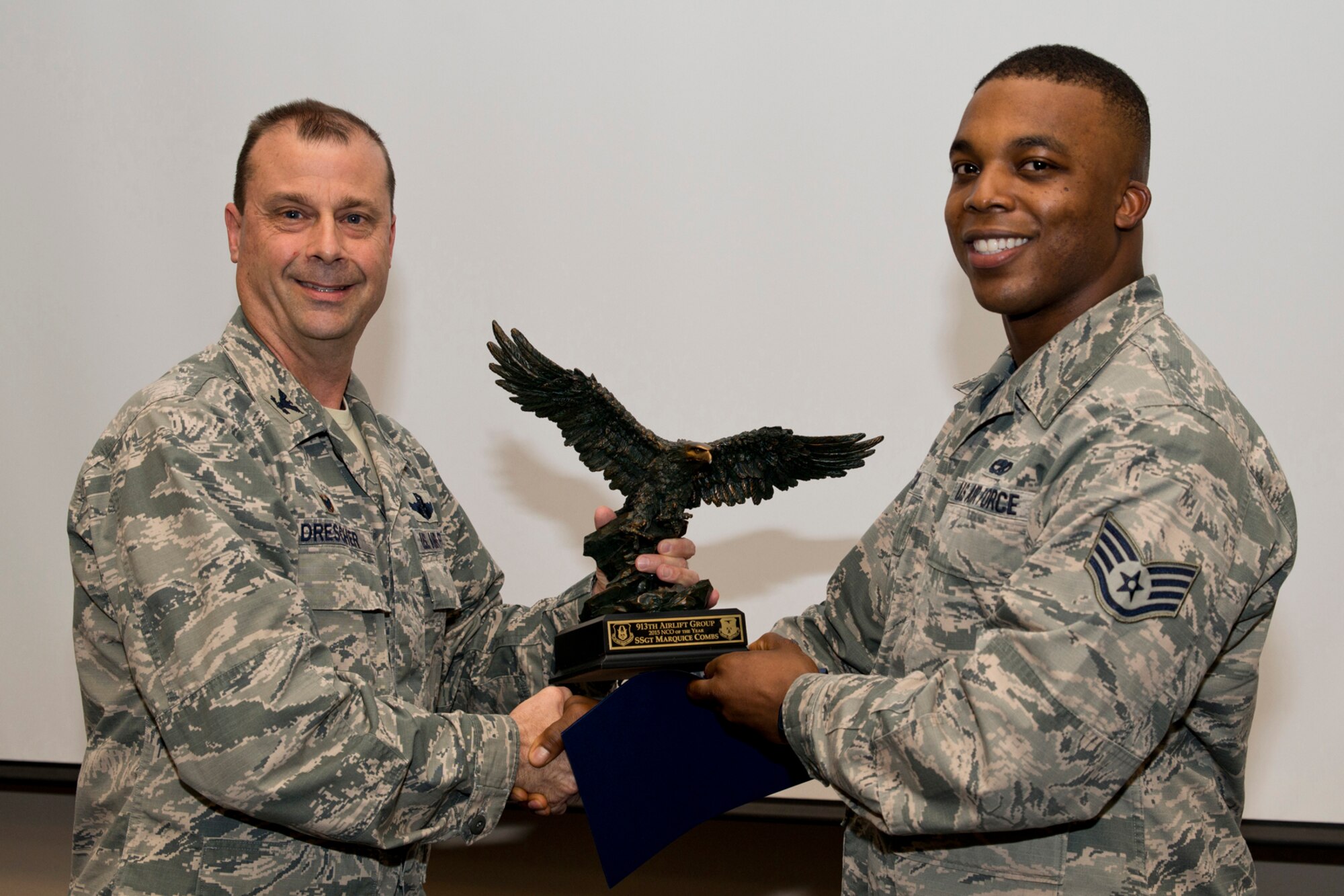 U.S. Air Force Reserve Col. Craig Drescher, commander, 913th Airlift Group, and Staff Sgt. Marquice Combs, a crew chief assigned to the 913th Maintenance Squadron, pose for a photo during a commander’s call at Little Rock Air Force Base, Ark., Mar. 13, 2016. Combs was presented the 2015 Non-commissioned Officer of the Year award for the 913 AG. (U.S. Air Force photo by Master Sgt. Jeff Walston/Released)