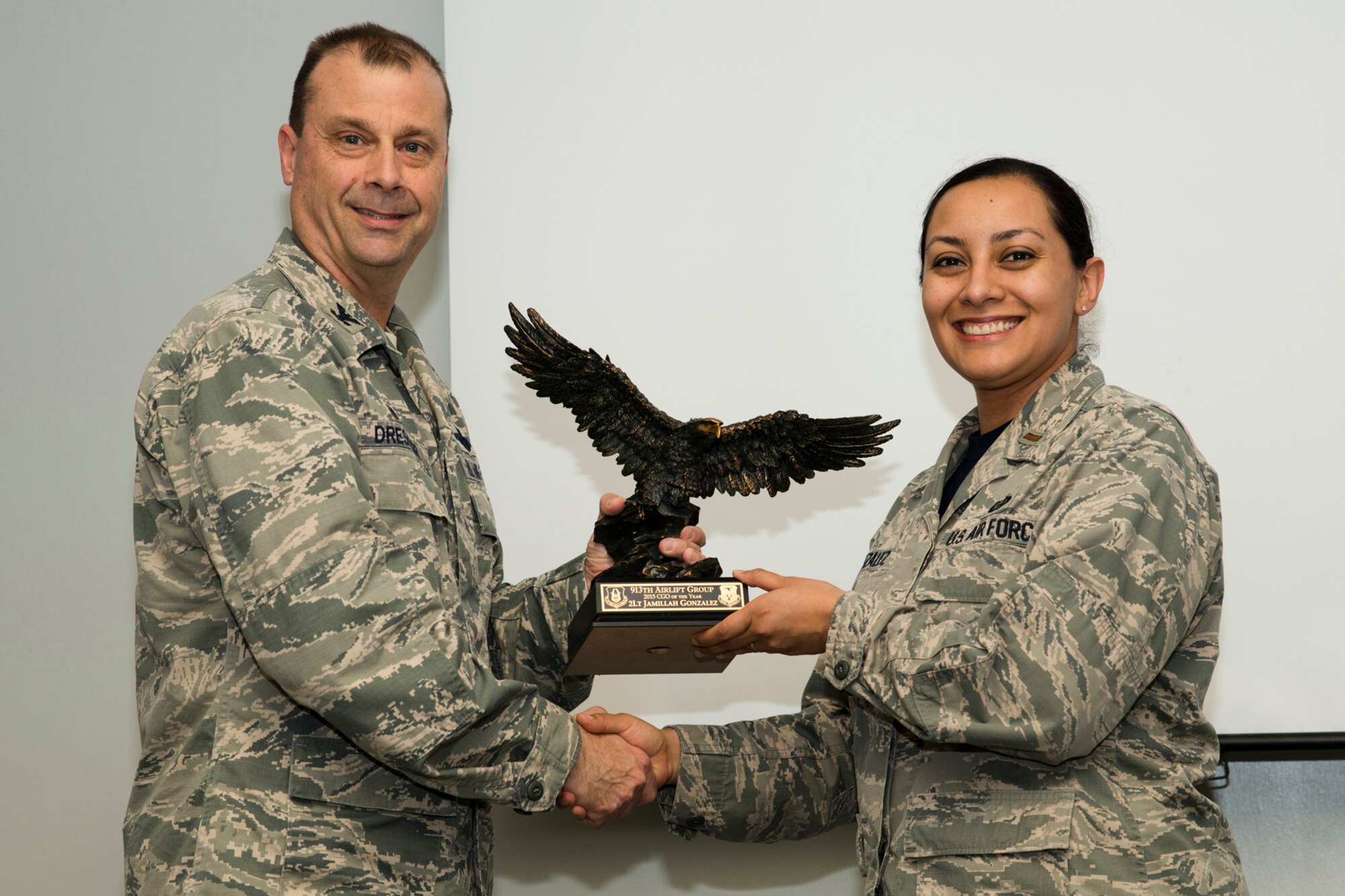 U.S. Air Force Reserve Col. Craig Drescher, commander, 913th Airlift Group, and 2nd Lt. Jamillah Gonzalez, director, Equal Opportunity, 913 AG, pose for a photo during a Commander’s Call at Little Rock Air Force Base, Ark., Mar. 13, 2016. Gonzalez was presented with the 2015 Company Grade Officer of the Year award for the 913 AG. (U.S. Air Force photo by Master Sgt. Jeff Walston/Released)