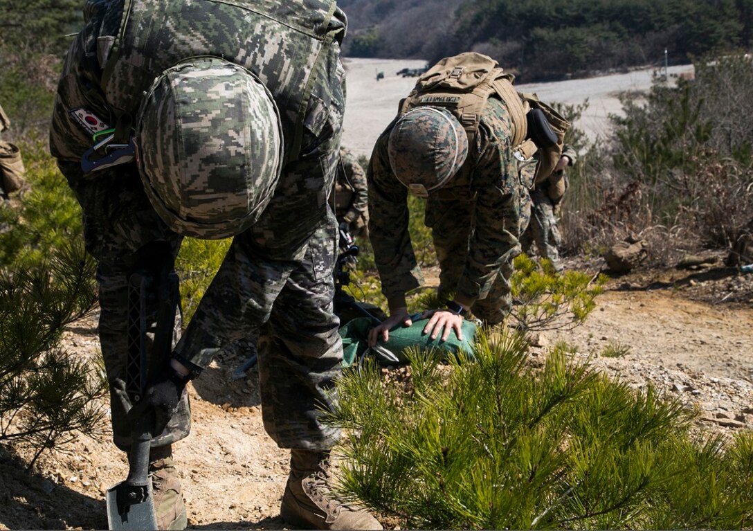 A U.S. and Republic of Korea Marine with Victor Unit 1/3, prepare a holding posistion, March 11, 2016, during Exercise Ssang Yong 2016 in Pohang, South Korea. Ssang Yong 16 is a biennial military exercise focused on strengthening the amphibious landing capabilities of the Republic of Korea, the U.S., New Zealand and Australia. (U.S. Marine Corps photo by Sgt. Briauna Birl/RELEASED)