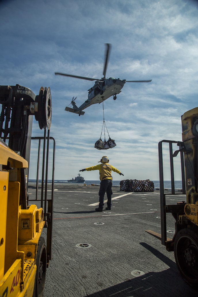 Sailors of the USS New Orleans conduct a resupply at sea with Helicopter Sea Combat Squadron 23 during their Western Pacific Deployment, March 5, 2016. More than 4,500 Marines and Sailors from the Boxer Amphibious Ready Group, 13th Marine Expeditionary Unit team are currently transiting the Pacific Ocean toward the U.S. 7th Fleet area of operations during a scheduled deployment. (U.S. Marine Corps photo by Sgt. Hector de Jesus/Released)