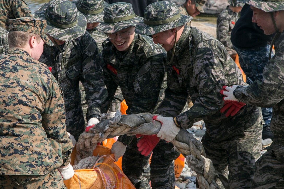 U.S. Marines and Sailors with the Boxer Amphibious Ready Group and 13th Marine Expeditionary Unit (MEU), work with Marines from the Republic of Korea, March 10, 2016, to clean a local beach in a combined effort to spread good community relations during Exercise Ssang Yong in Pohang, South Korea.  Ssang Yong is a biennial military exercise focused on strengthening the amphibious landing capabilities of the Republic of Korea, the U.S., New Zealand and Australia. (U.S. Marine Corps photo by Sgt. Briauna Birl/RELEASED)
