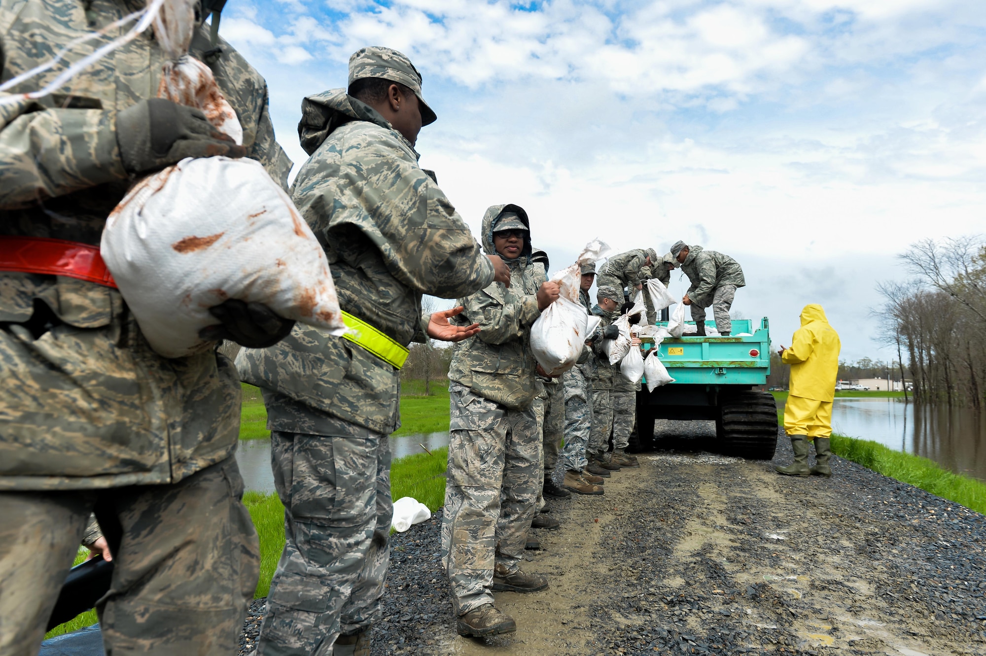 Barksdale Airmen unload sandbags from a city vehicle in Bossier City; La.; March 10; 2016. Airmen created a protective barrier over The Red Chute Bayou levee in an attempt to slow down corrosion caused from excess waters flowing down from the ArkLaTex region. (U.S. Air Force photo/Senior Airman Mozer O. Da Cunha)