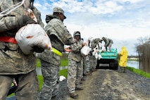 Barksdale Airmen unload sandbags from a city vehicle in Bossier City; La.; March 10; 2016. Airmen created a protective barrier over The Red Chute Bayou levee in an attempt to slow down corrosion caused from excess waters flowing down from the ArkLaTex region. (U.S. Air Force photo/Senior Airman Mozer O. Da Cunha)