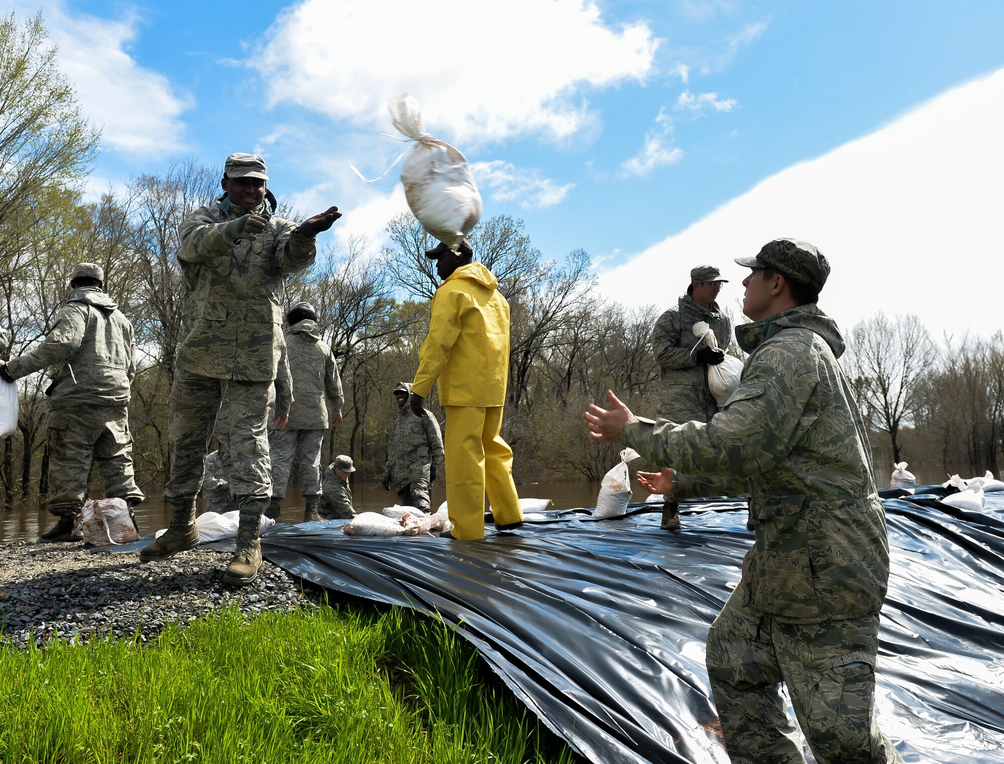 An Airman with the 2nd Logistics Readiness Squadron throws a sandbag to his partner in Bossier City, La., March 10, 2016. The Red Chute Bayou levee served as a barrier and kept waters out of surrounding neighborhoods. (U.S. Air Force photo/Senior Airman Mozer O. Da Cunha)