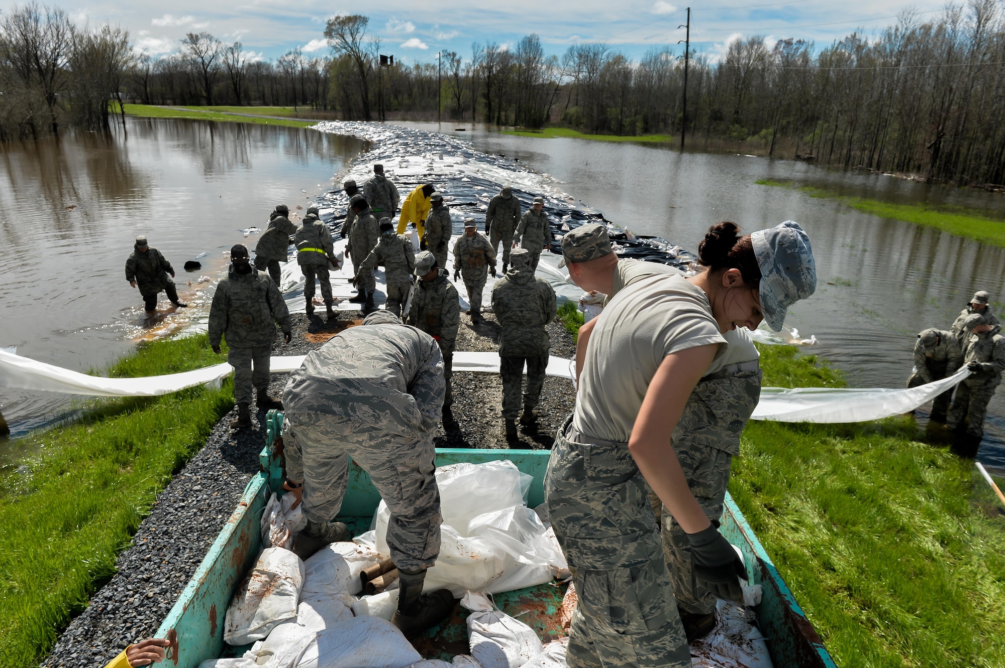 Barksdale Airmen build a protective barrier over a levee in Bossier City, La. March 10, 2016. Airmen worked in unison with the Army Corps of Engineers and local city employees to transport, unload and place sandbags at the lowest sections of the Red Chute Bayou levee. (U.S. Air Force photo/Senior Airman Mozer O. Da Cunha)