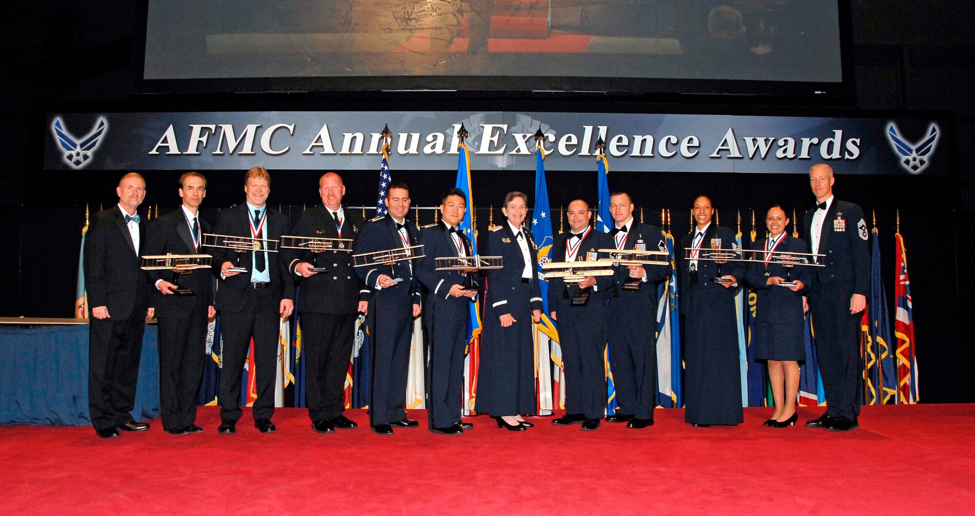 Air Force Materiel Command's 2015 Annual Excellence Award winners gather with AFMC leadership after the awards ceremony March 9, 2016. From left are Michael Gill, AFMC Executive Director; Andrew Mendoza; Eric Brickson; Steven Smith; Maj. David Jarnot; Capt. Jae Jeon; Gen. Ellen Pawlikowski, AFMC Commander; Master Sgt. Brian Partido; Master Sgt. Randy McKenzie; Technical Sgt. Kasmir Alford; Senior Airman Raquel Caramanno; and Chief Master Sgt. Michael Warner, AFMC Command Chief. (U.S. Air Force photo/Albert Bright)